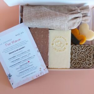 Coffret cadeau MöBiUS fête des mères, ouvert, avec savons, shampoing et accessoires sur fond saumon.