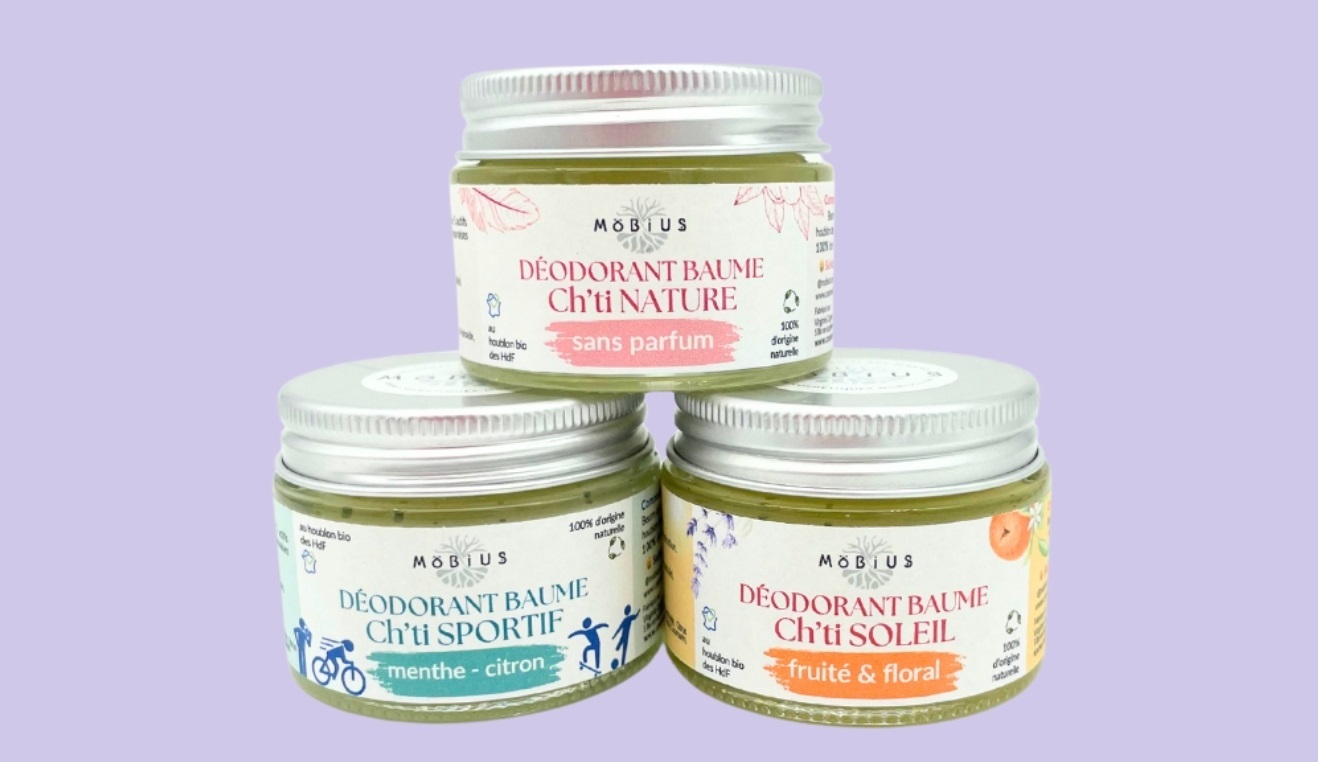 Trio de déodorants Ch'ti (Soleil, Sportif, Nature) en pots de verre avec étiquettes imprimées, disposés sur un fond mauve.