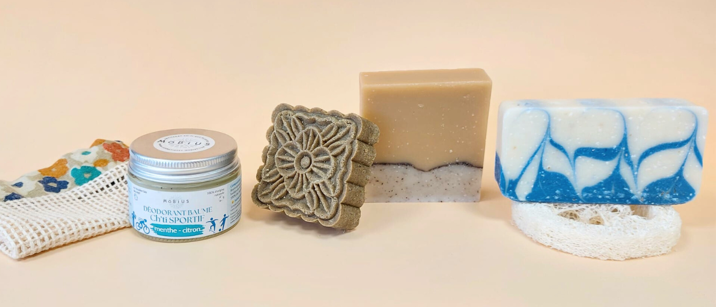 Soins cosmétiques solides Möbius sur fond orangé pastel : savon naturel, shampoing solide, déodorant Ch’ti Sportif et filet sauve-savon zéro déchet