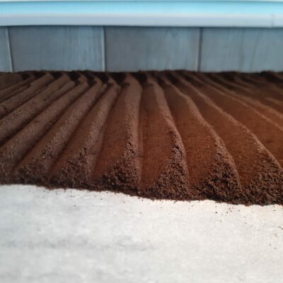 Marc de café étalé en forme de pyramide sur un plan de travail pour le faire sécher