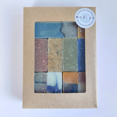 Coffret kraft MöBiUS contenant 11 mini-savons saponifiés à froid visibles à travers une fenêtre transparente.