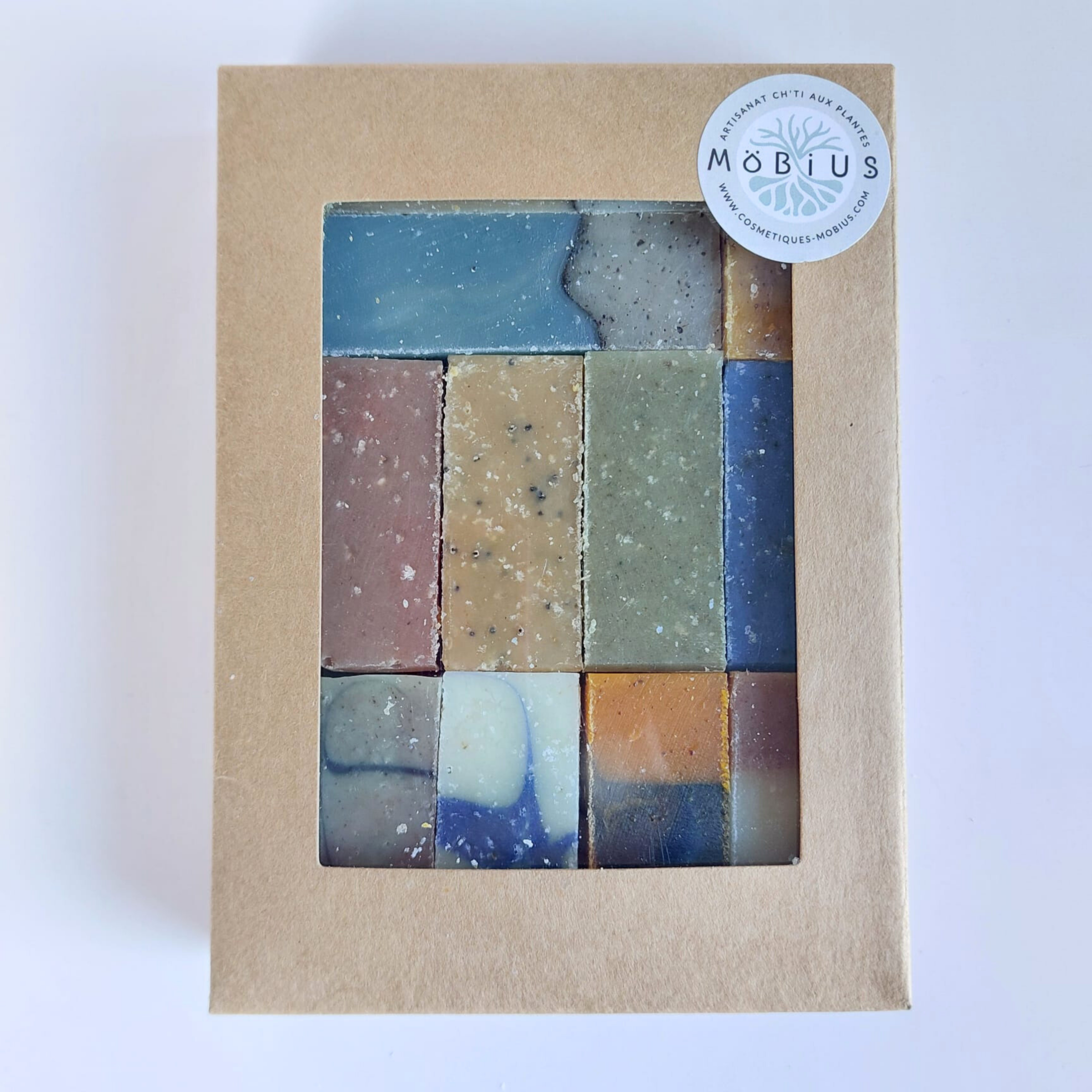 Coffret kraft MöBiUS contenant 11 mini-savons saponifiés à froid visibles à travers une fenêtre transparente.